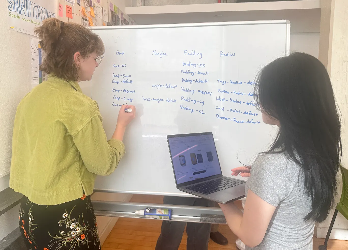 Claire and a teammate defining gap, margin, padding, and radius tokens on a whiteboard